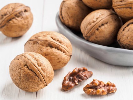 Inshell walnut on white wooden background