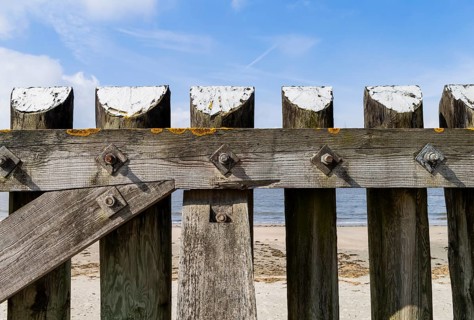The photo shows a solid wooden fence on the island of Baltrum