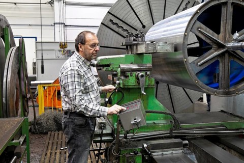 An older worker in the metal industry at a CNC milling machine. Austria