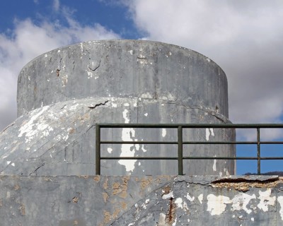 An old crumbling concrete military bunker type structure with rounded windowless surfaces and a