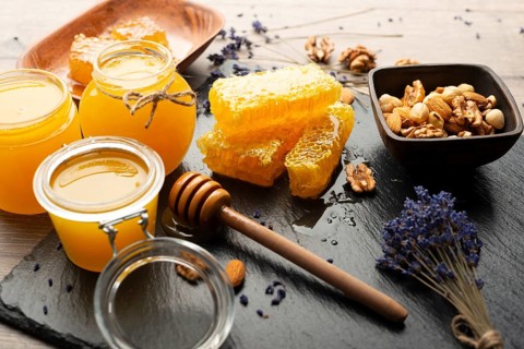 Honeycomb on slate tray with honey and nuts on kitchen table, food photography, food photography