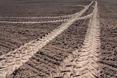 Tractor tracks, agricultural trails at a cultivated field in springtime, farmland near Wesertal,