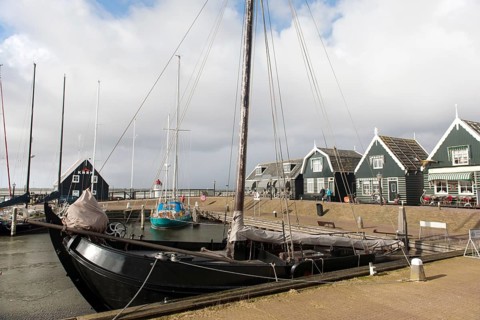 Groene houten huizen in het haventje van Marken