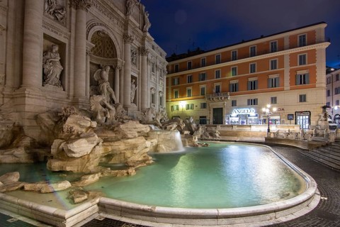 The Trevi Fountain, one o'clock in the morning at the blue hour. No people, but well lit.