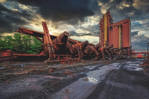 Dilapidated agricultural facility with a silo at sunset under dark clouds, HF6, Lost Place,