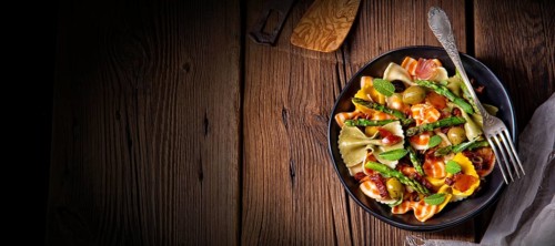Pasta salad with green asparagus, olives and Parma ham