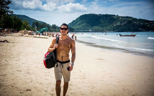 Half body shot of a handsome young man standing on a beach in Phuket Island, Thailand, shirtless