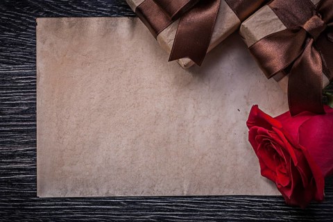 Vintage paper red natural rose wrapped giftboxes on wooden board