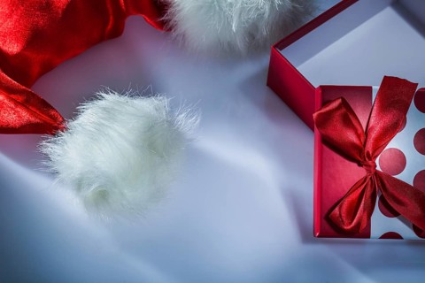 Santa cap wrapped gift box on white background