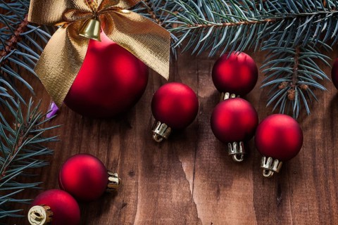 Christmas balls bow and fir tree branch on wood board