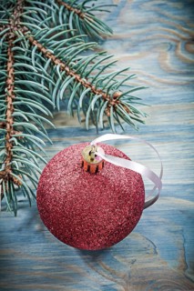 Pine branch red bauble on wooden board holidays concept