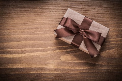Packed gift on vintage wooden board top view holidays concept