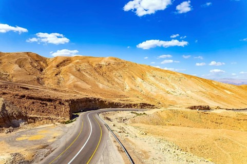 Desert on the shores of the Dead Sea. Israel. Asphalt highway meanders among the hills. Dead Sea