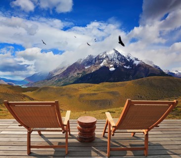 Pleasant holiday. Chile. Wooden chairs in the park Torres del Paine. On the horizon is visible