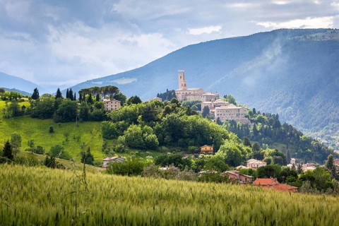 An image of Camerino in Italy Marche over colourful fields