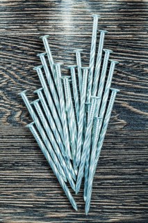 Heap of construction nails on wooden board