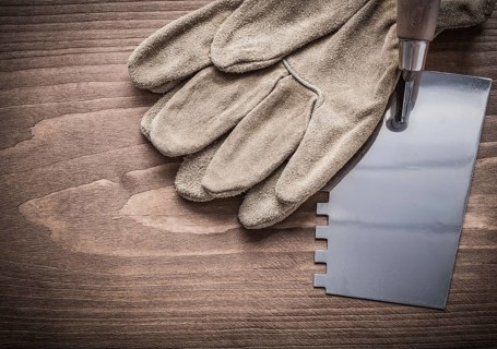 Working gloves and putty spattle on wood board