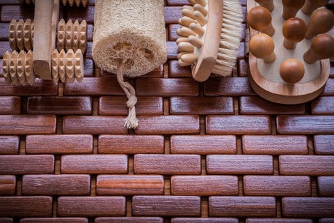 Wood scrubbing brush massagers and loofah on textured wooden place mat healthcare concept