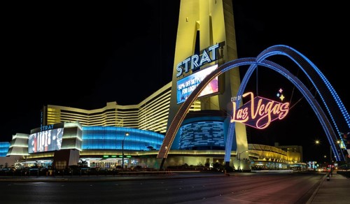 A picture of the STRAT Hotel, Casino and SkyPod and Las Vegas Boulevard Gateway Arches at night