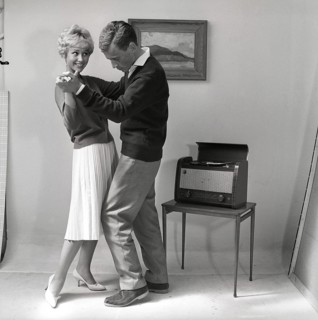 Learning to dance in the 1950s. A young copule is dancing in a photographers studio. The young