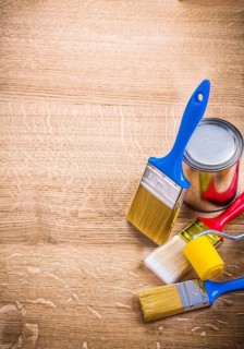 Organized copyspace three paint brushes roller can on wooden board construction concept