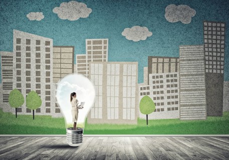 Businesswoman inside light bulb against city drawn concept