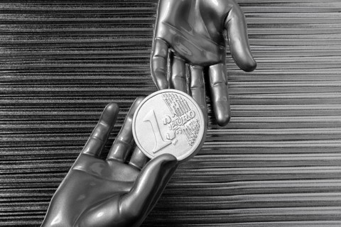 Silver euro coins in futuristic robot gray metallic hands bank metaphor