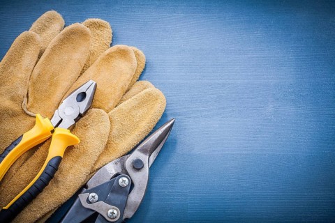 Pliers steel cutter leather protective gloves on wooden board