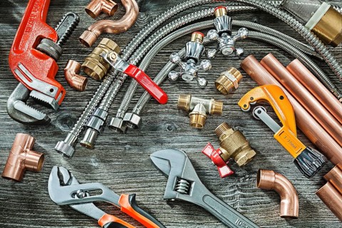 Plumbing concept big set of piping accessories monkey and plumb adjustable wrenches copper brass