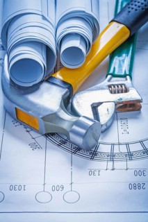 Blueprint rolls adjustable spanner and claw hammer construction concept