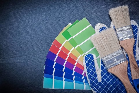 Paintbrushes pantone fan safety gloves on wooden board