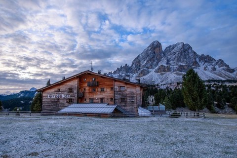 Utia de Borz hut in Passo Erbe after sunrise at the mountain Peitlerkofel, or Sass de Putia