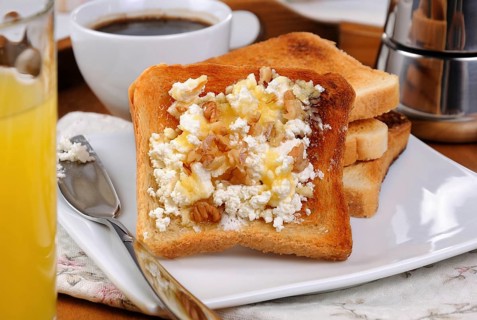 Crisp, fresh toast ricotta, honey and nuts for breakfast with orange juice and coffee