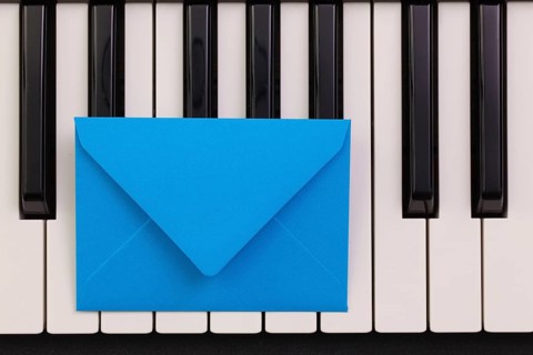 Funny arrangement envelope on the piano keybords - Flat lay image