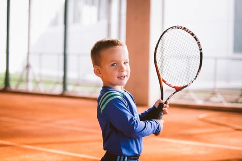 Child playing tennis on outdoor court. September 20, 2016, Ukraine, Kiev. Little tennis great