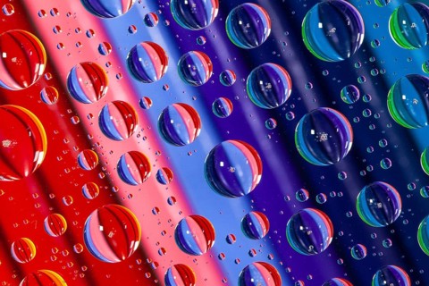 Color pencils under glass with drops of water. Office concept