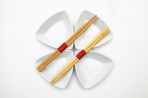 Ceramic bowls and bamboo chopsticks for sushi food with red and white decoration