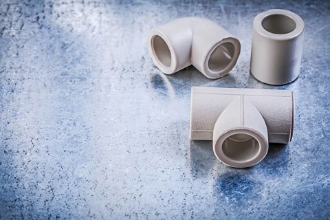 Plastic pipe connectors on metallic surface construction concept