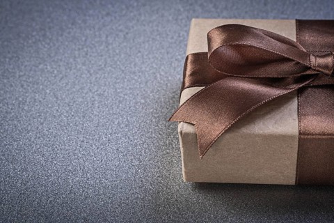 Boxed gift with brown knot on grey background copy space celebrations concept