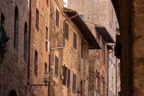 Facade of typical medieval residential houses in downtown San Gimignano, Italy, Europe