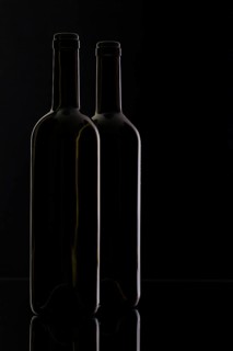 Two different bottles of wine on the black background