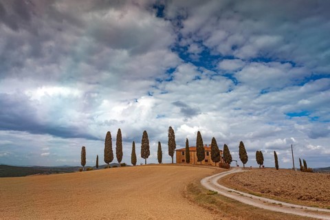 Dreamy landscape in Tuscany with cypresses and a lonely house in sunny weather, Pienza, Val