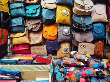 Handmade colourful leather bags and purses on display at traditional souk - street market in
