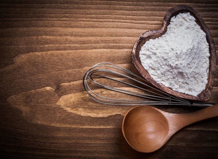 Wooden spoon heartshape bowl flower beater on wood board