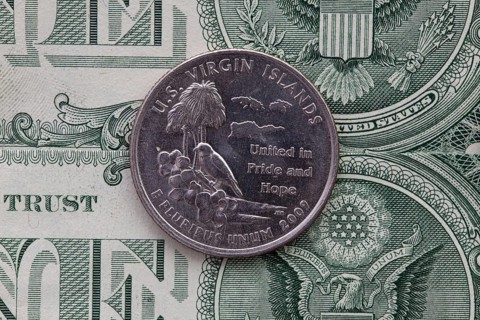 A quarter of U.S. Virgin Islands on US dollar bills. Symmetric composition of US dollar bills and a