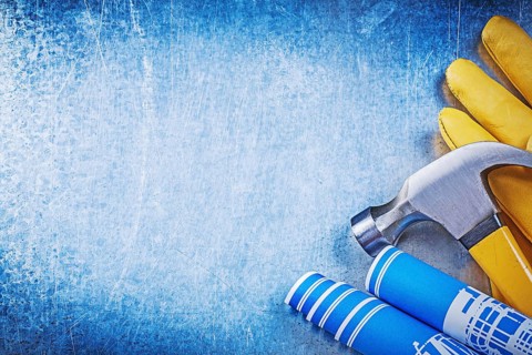 Protective working gloves blue rolled construction drawings claw hammer