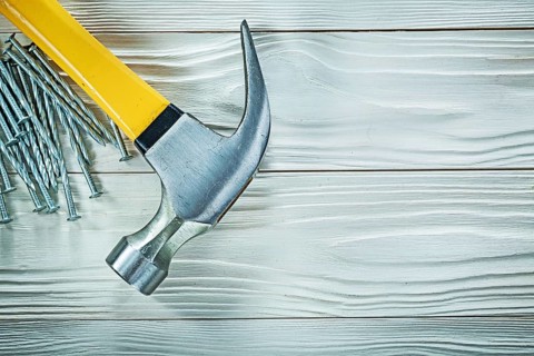 Claw hammer construction nails on wood board
