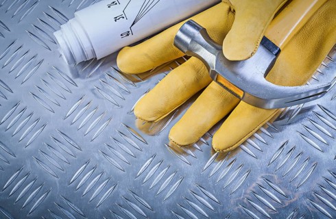 Claw hammer leather protective gloves construction drawings on corrugated metal sheet