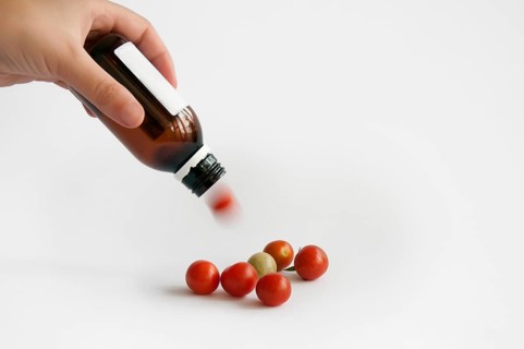 Tomatoes from the medication bottle solated on white
