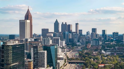 Aerial views of Atlanta showcase a vibrant cityscape with sleek skyscrapers, lush green spaces, and